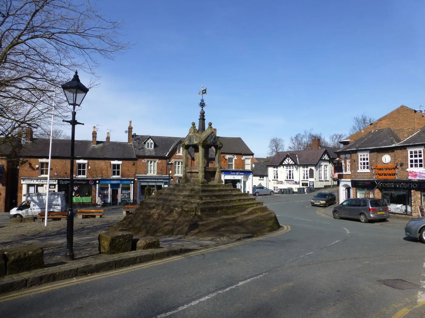 Lymm Cross, with the shops and cafes of The Cross behind it