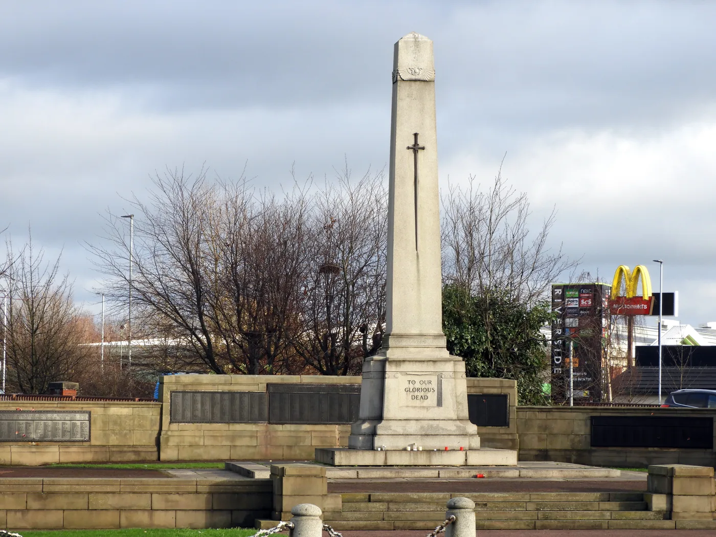 Warrington Cenotaph at Bridge Foot, where the borough service is held. The Riverside Retail Park sign behind it is inside the 8am to noon closure.